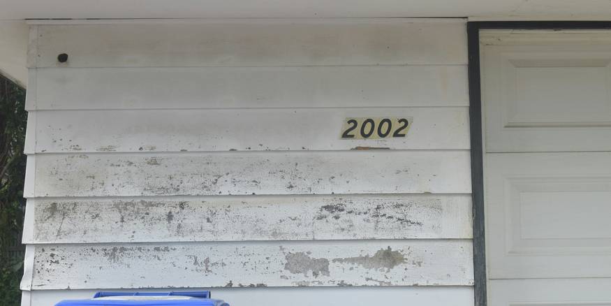 Eviction notice posted on an apartment door in Ohio, with a worried tenant in the background, representing the legal eviction process