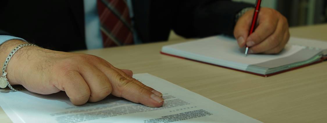 Landlord and tenant signing a lease agreement at a table, closeup on hands and paperwork, representing Ohio rental contracts